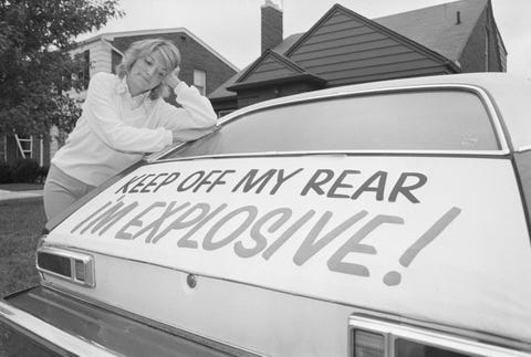 Woman Leaning on Ford Pinto with Warning Sign