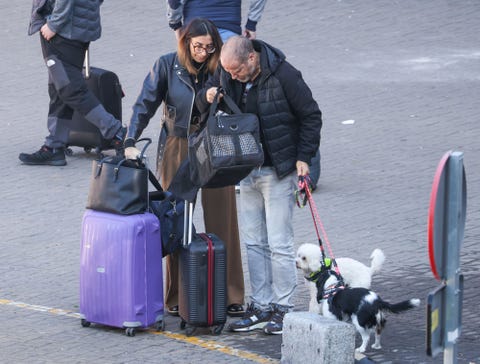 la pareja, muy cargados, salen de viaje