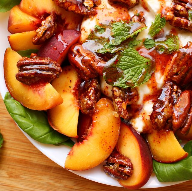 peach burrata basil salad topped with hot honey, candied pecans, and mint