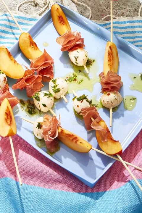 peach and prosciutto skewers on a blue plate