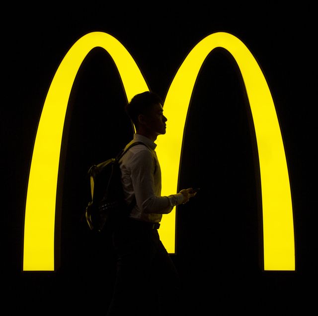 a pedestrian walks past an american fast food hamburger