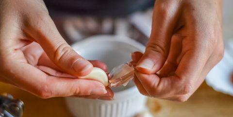 peeling garlic to make a cooking sauce close up