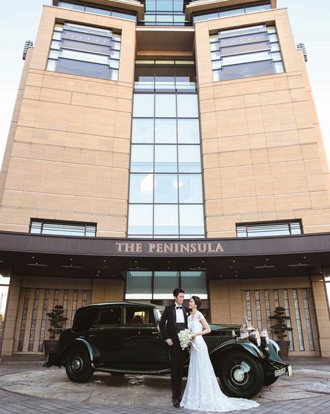 「ザ・ペニンシュラ東京」の外観とロールス・ロイスの前に立つ新郎新婦の写真。