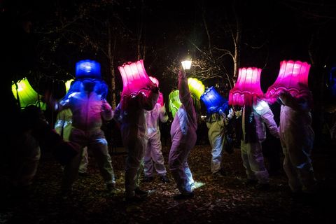 People Dancing With Lamp Shades On Head During Light Festival
