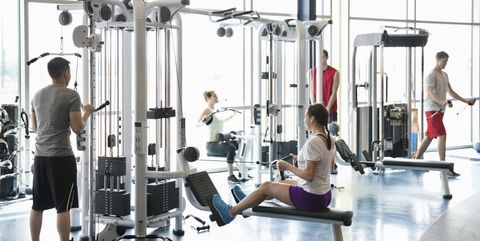People using weight machines in fitness center