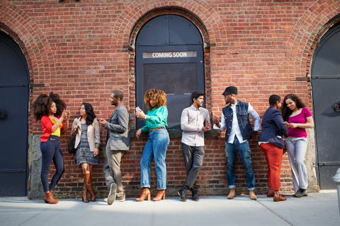 People waiting in line at theater using cell phones