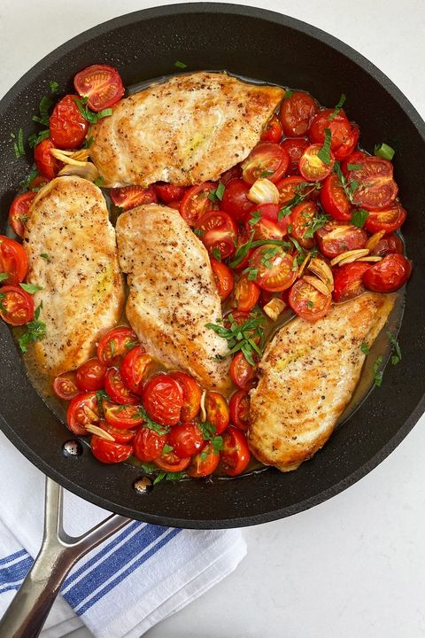 skillet roasted chicken and tomatoes in black skillet in cast iron skillet pan