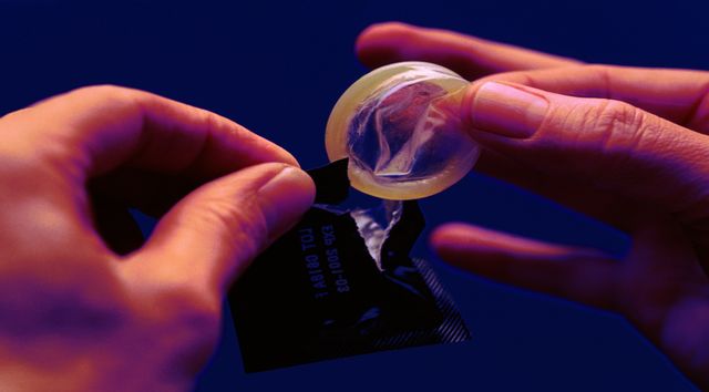person removing condom from packet, close up
