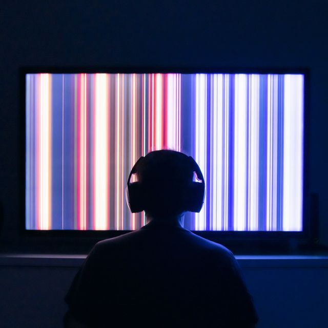 person sitting in front of a tv screen with headphones