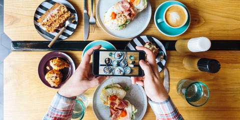 Personal perspective view of man photographing his brunch in cafe with smartphone Personal perspective view of man photographing his brunch in cafe with smartphone