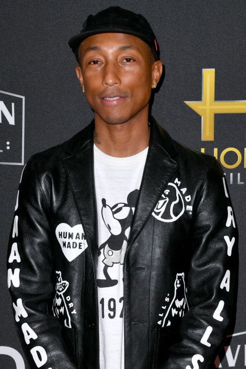 pharrell wears a mickey mouse tshirt and a black leather jacket on the red carpet