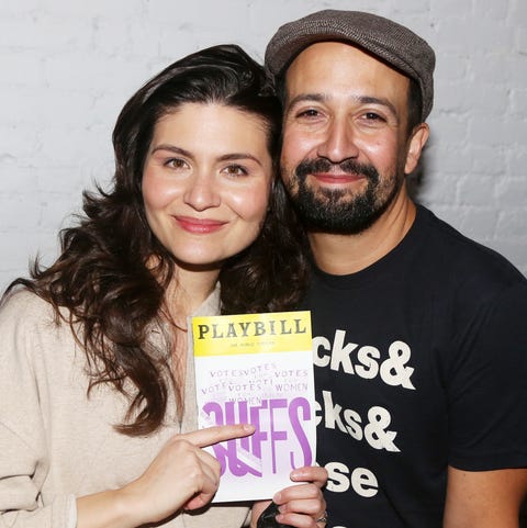 phillipa soo pointing to a suffs playbill while standing next to lin manuel miranda