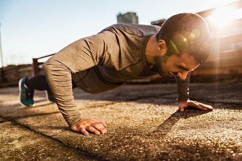 Photo of a athletic man doing push ups outdoors