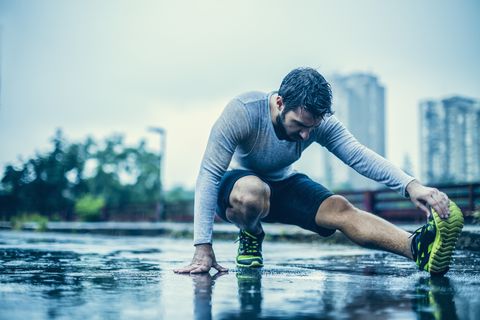 Photo of a man stretching in the rain