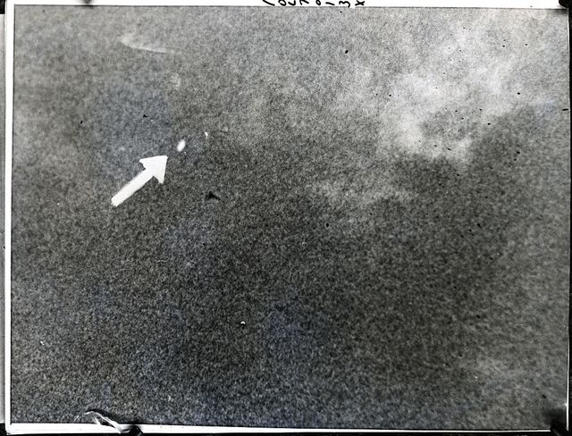 arrow points to ufo in grainy sky photo