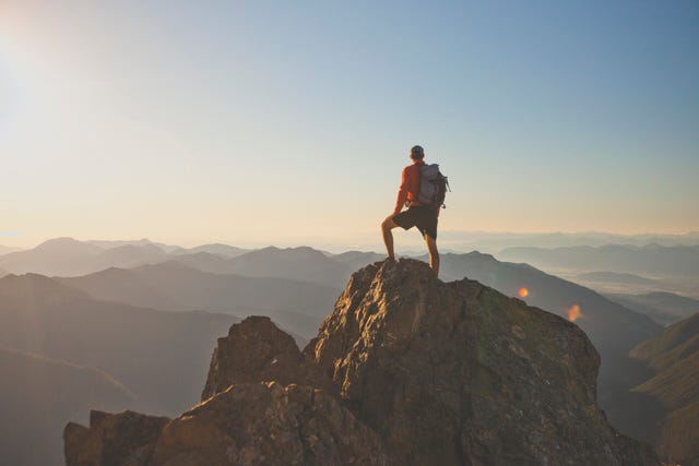 Photograph of adventurous backpacker standing on mountain peak, North Cascades National Park, Washington State, USA adventurous backpacker standing on mountain peak, north cascades national park, washington state, usa