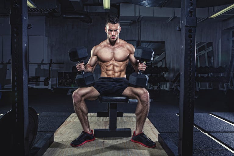 Physical athlete doing dumbbell bench presses