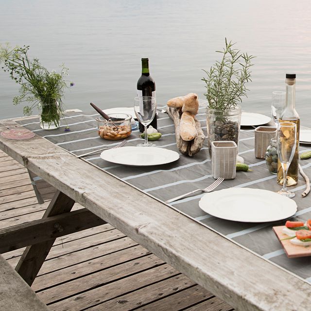 dinner set on wooden picnic table next to lake
