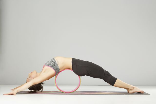 pilates stretching  training  yoga wheel poses woman practicing advanced yoga