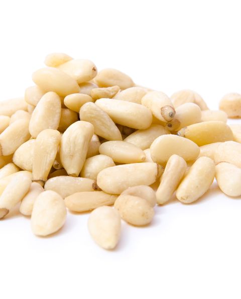 Pile of white pine nuts on a white background