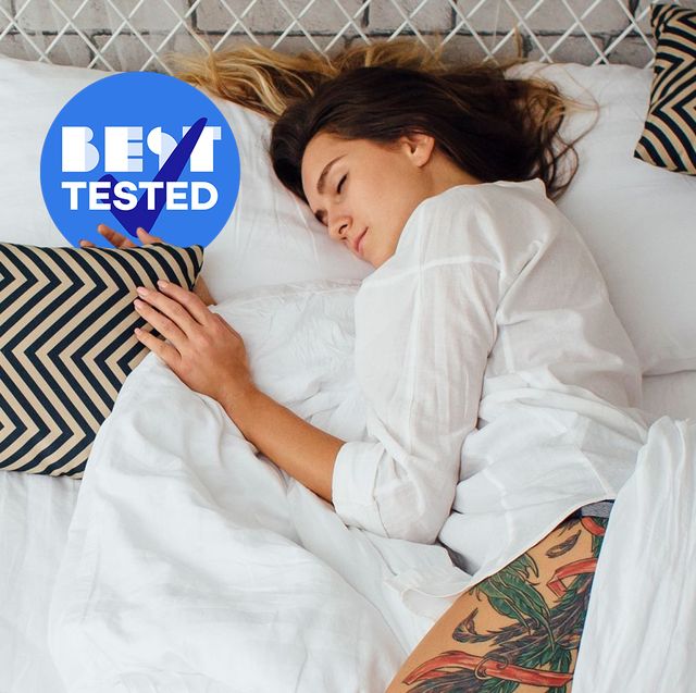 best tested woman sleeping on side in white bed with patterned pillows