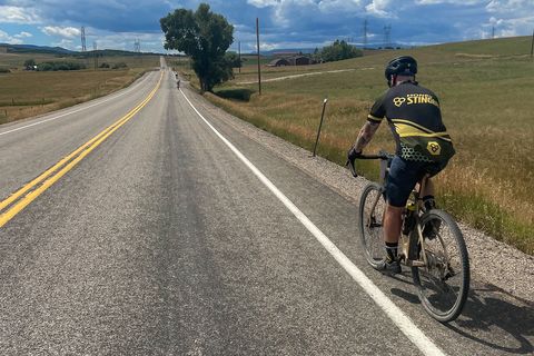 Man riding a pinarello grevil f ekar gravel bike on a tarmac road