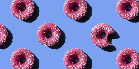 pink doughnut on pastel blue background chewed donut
