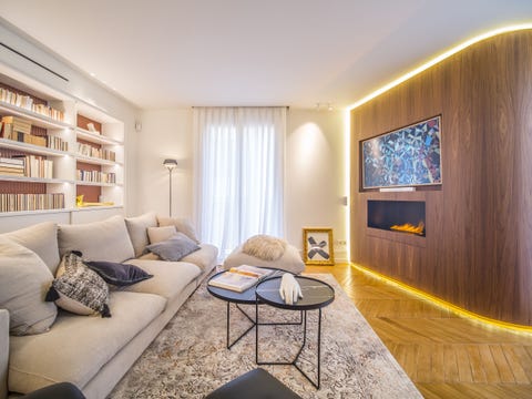 salón moderno con chimenea, librería de obra y sofá gris