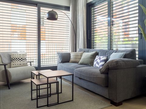 salón de estilo moderno e industrial con sofá gris y mesas nido