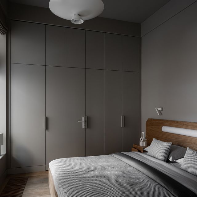 dormitorio con armarios empotrados grises y cabecero de madera