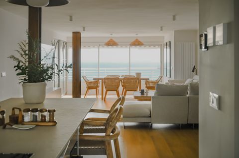 cocina abierta al salón comedor de estilo minimalista cálido con muebles en tonos neutros y madera
