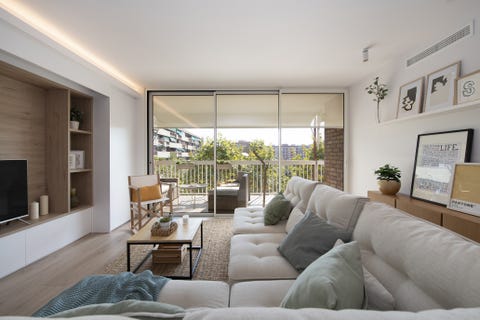 salón de diseño nórdico con sofá rinconera modular, mesa de centro de madera y acero y alfombra de fibras