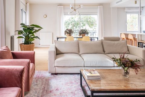 salón abierto con sofá beige y butacas de terciopelo rosa