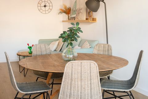salón comedor con mesa redonda de madera y sillas de fibras