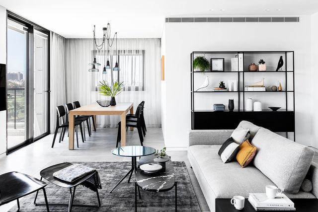un piso moderno, abierto y decorado en blanco, negro y gris para una pareja de jubilados