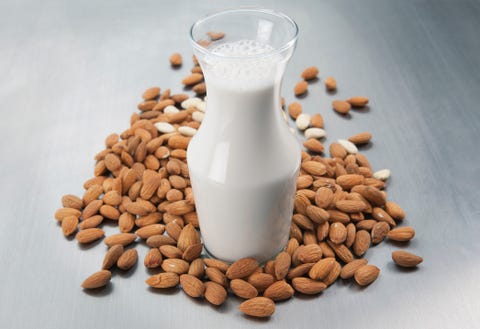 Pitcher of milk and raw almonds Pitcher of milk and raw almonds
