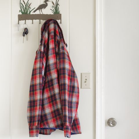 plaid shirt hanging on coat hook on white wall