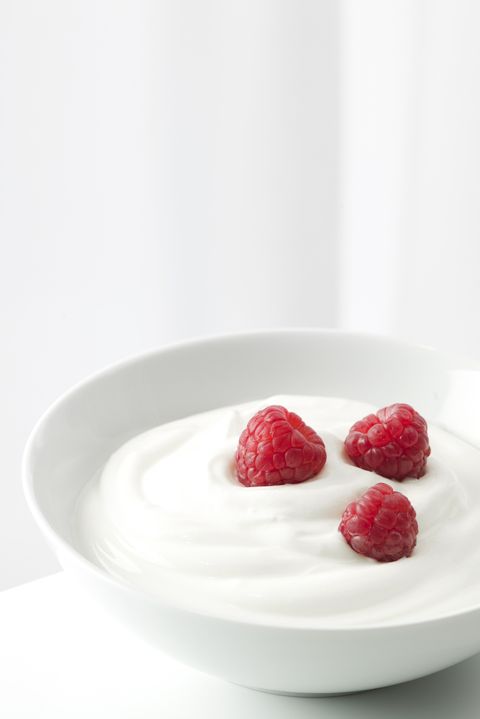 Yogurt with raspberries in a white bowl