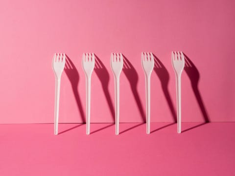 plastic white forks on pink background