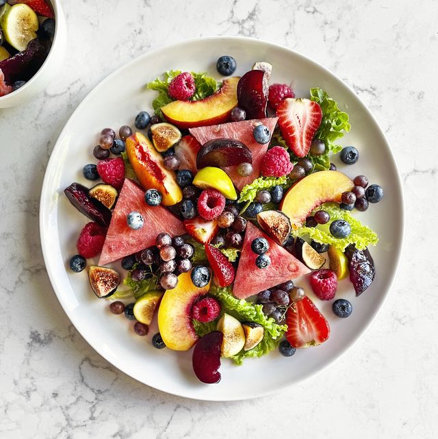plate of fruit salad on white, marble background