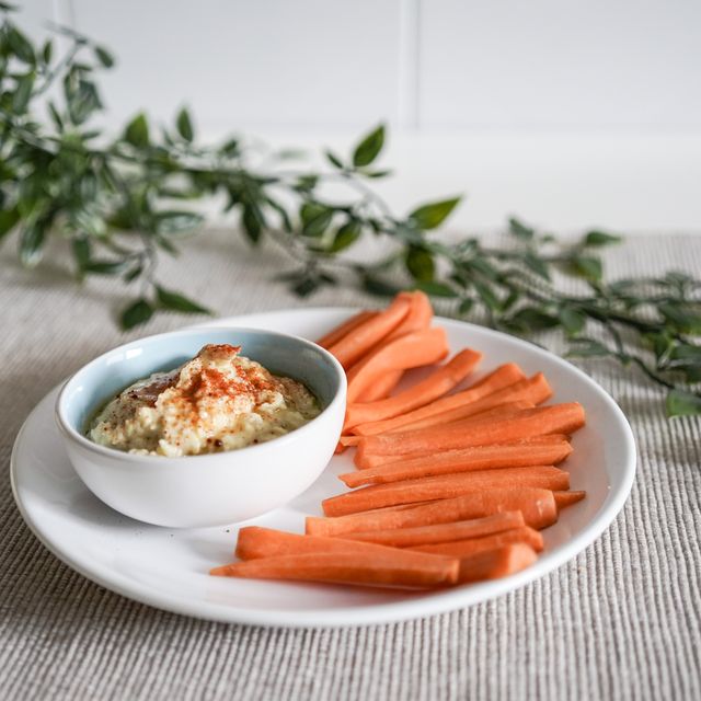 plate of hummus accompanied by carrot