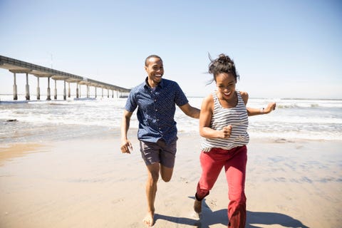 Playful couple running on sunny beach Playful couple running on sunny beach