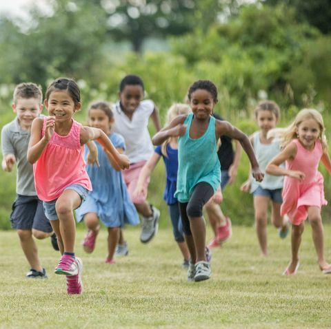 kids running outside in a field on a sunny day for exercise