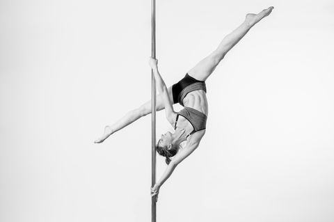 pole-dancer-performing-against-white-background-royalty-free-image-985858290-1566552768.jpg