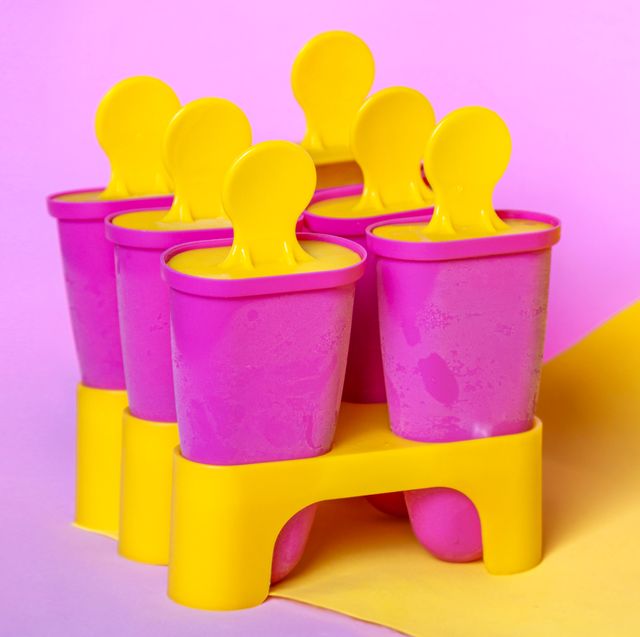 homemade popsicles, ice cream sticks on bright pink yellow colors background