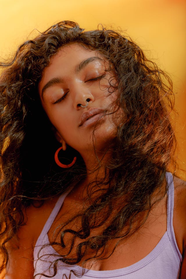 portrait of a young confident woman closing her eyes with windswept hair