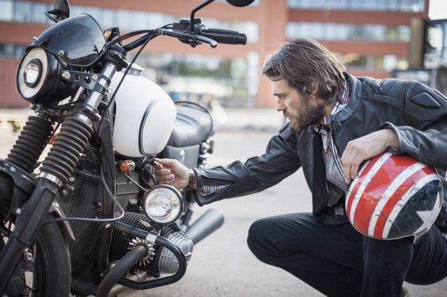 portrait of bearded man looking at a motorcycle