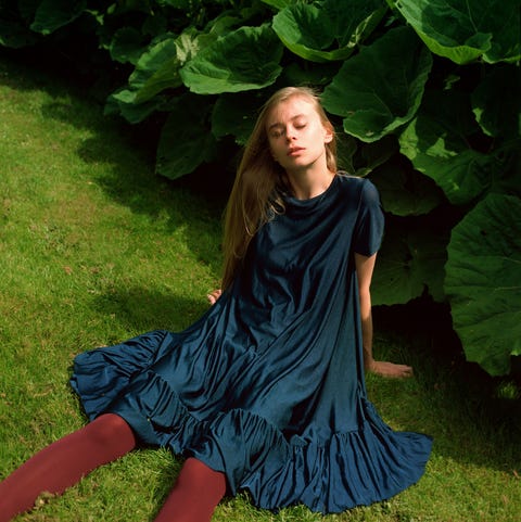 Portrait of beautiful young woman relaxing in meadow