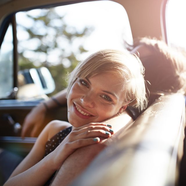 portrait of cute woman in car, at sunset