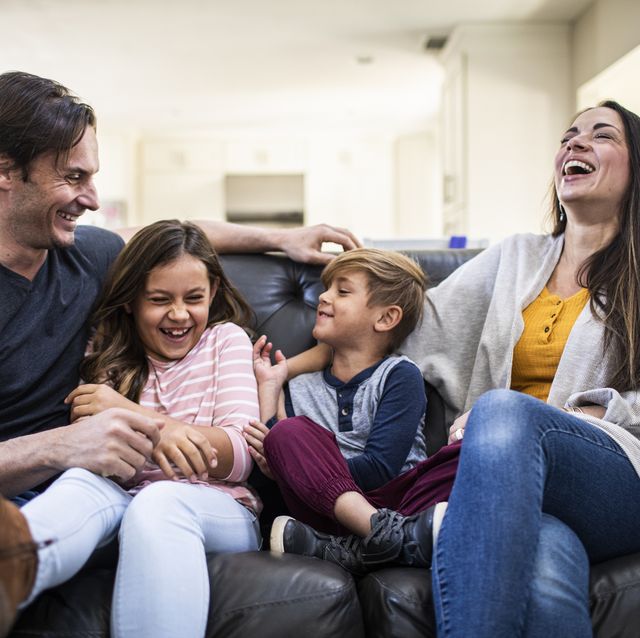 familia riendo con niños en el sofá